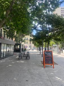 un trottoir avec des tables et des chaises dans une rue de la ville dans l'établissement Appartement chic plage des Catalans, à Marseille