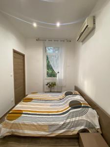 Cette chambre blanche dispose d'un grand lit et d'une fenêtre. dans l'établissement Appartement chic plage des Catalans, à Marseille