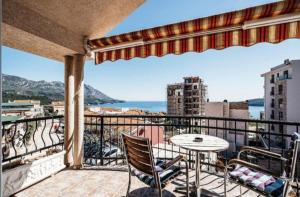 a balcony with a table and chairs and the ocean at D & S Family Apartments Budva in Budva