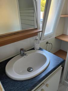une salle de bain avec un lavabo blanc et un miroir dans l'établissement Mobil home bungalow 6 personnes villeneuve loubet plage marina baie des anges, à Villeneuve-Loubet 23 autres photos