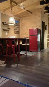 cocina con mesa y nevera roja en Casa Almendro, en Monte Grande