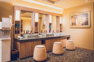 un bagno con due lavandini e due sgabelli di Hotel Grand View Takasaki a Takasaki