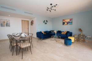 ein Wohnzimmer mit einem blauen Sofa und einem Tisch in der Unterkunft Blu paradise,a ray of sunshine between sea & pool in Agadir