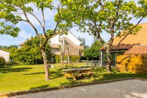 une table de pique-nique dans un parc à côté de deux arbres dans l'établissement greet hôtel restaurant Angoulême Ouest, à Saint-Yrieix-sur-Charente