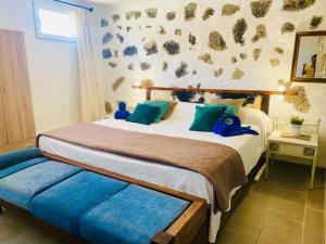 Un dormitorio con una cama con dos animales de peluche azules. en Esencia&Alma en El Charco