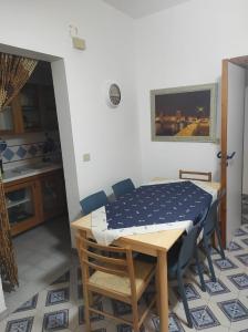 una sala da pranzo con tavolo e sedie e una cucina di Villetta Gallipoli Baia Verde Tigli 33 a Gallipoli