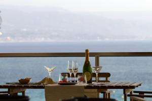 - une table avec des verres et une bouteille de vin dans l'établissement Luxury Apartment, à Messina
