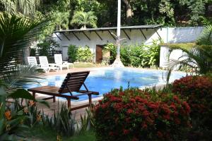 a chair sitting next to a swimming pool at Eco Hostal Kuima in El Zaino