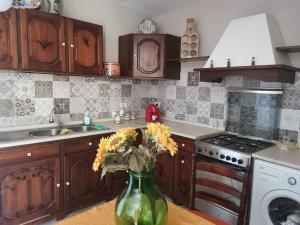 una cocina con un jarrón verde con flores. en Le case di Grazia, en Ioppolo Giancaxio