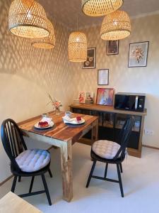 - une salle à manger avec une table en bois et 2 chaises dans l'établissement Ferienwohnung Ptit Monde, à Friedrichshafen