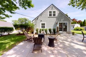 a patio with benches in front of a house at Harborside Retreat in Falmouth