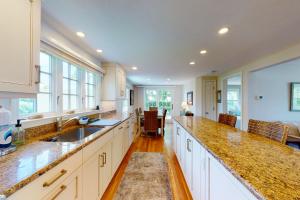 a kitchen with white cabinets and a counter top at Harborside Retreat in Falmouth