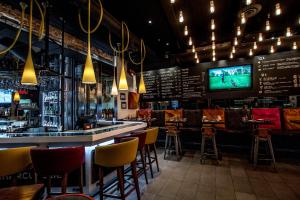 a bar with chairs and a tv in a restaurant at Hôtel Boutique Ophelia - Par Aneyro in Quebec City