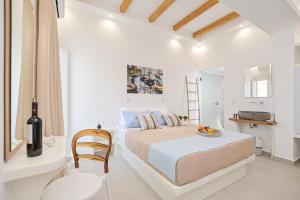 ein weißes Schlafzimmer mit einem Bett und einer Flasche Wein in der Unterkunft Elite Suites Naxos in Naxos Chora