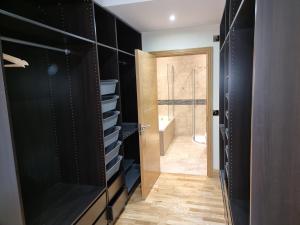 a walk in closet with black cabinets and a door at St Martins House Apartments in Tranent