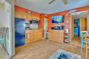 cocina con paredes de color naranja y armarios de madera en Belleair Beach Club 312 en Clearwater Beach