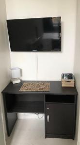 einen schwarzen Schreibtisch mit einer Mikrowelle darüber in der Unterkunft Studio lumineux Saint-Ideuc à 1km de la plage in Saint-Malo