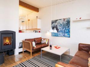a living room with a couch and a fireplace at 6 person holiday home on a holiday park in Sæby in Sæby +23 photos