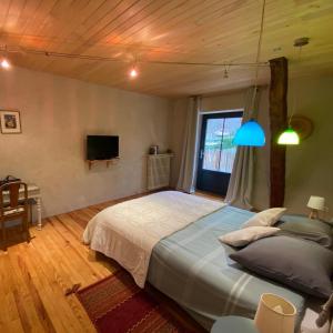 una camera con un grande letto e una TV di Maison de Vacances a Loubejac