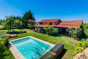 un patio trasero con piscina y una casa en Quinta da Pereira, en Armamar