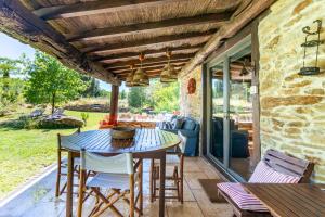 a patio with a blue table and chairs and a stone building at Quinta da Pereira in Armamar