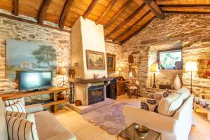 a living room with a fireplace and a stone wall at Quinta da Pereira in Armamar