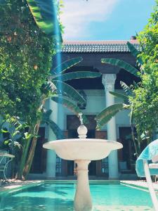 a fountain in the middle of a swimming pool at Riad Slitine & Spa in Marrakesh