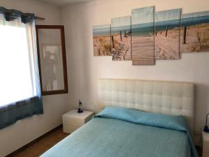 a bedroom with a bed and a painting of a pier at Case dei limoni sul mare in Capoliveri