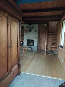 an empty living room with a fireplace and wooden floors at Domek Stojkowo in Stojkowo