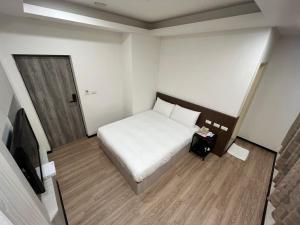 a small bedroom with a bed and a television at New KM Hotel in Jincheng