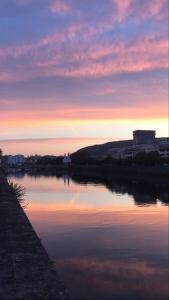 une masse d'eau avec un coucher de soleil en arrière-plan dans l'établissement Luminoso apartamento en el centro de San Sebastián, à Saint-Sébastien