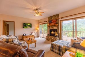 a living room with a couch and a fireplace at Condo with Stunning Mountain and 6th Green views near Harrahs Cherokee Bryson City in Whittier