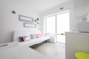 sala de estar blanca con sofá y ventana en CASASUPERTUBOS® Villa 9 & Apart 1-8, en Atouguia da Baleia