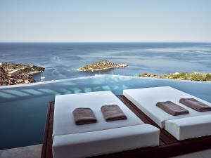 two beds on a swimming pool with a view of the ocean at Yoma Cove Suites in Volímai