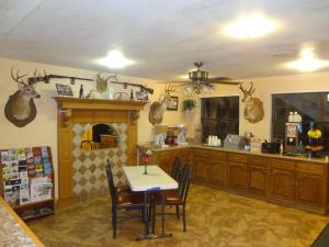 una cocina con mesa y algunos cuernos en la pared en Antlers Inn Goliad en Goliad