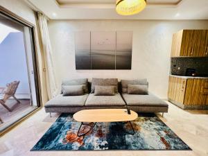 a living room with a couch and a table at OceanParc - Vue sur Mer et Parc 24H Sécurité in Mohammedia