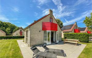 una casa con 2 sillas y un banco en un patio en Awesome Home In Ewijk With House A Panoramic View en Ewijk