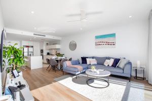 een woonkamer met een blauwe bank en een tafel bij Level 30 Oracle Tower 2 Stunning views and free parking - GC Getaways in Gold Coast