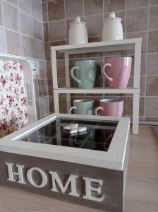 a hongrine with cups and mugs on shelves at Casa nella Natura Il Risveglio degli Elfi in Pedavena