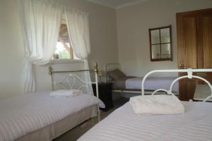 A bed or beds in a room at Bentwood Olive Grove Accommodation
