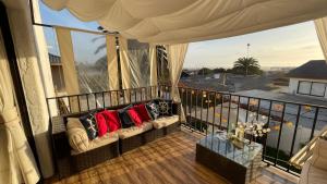 a balcony with a couch with red pillows on it at Calor De Hogar La Serena in La Serena