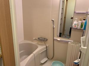 a bathroom with a bath tub and a sink at Buchoho No Yado Morioka in Morioka