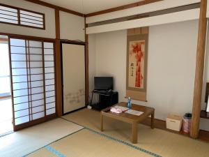 sala de estar con mesa y TV en Buchoho No Yado Morioka, en Morioka
