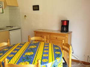 une cuisine avec une table et une couverture jaune et bleue. dans l'établissement Studio Le Biot, 1 pièce, 4 personnes - FR-1-573-94, à Le Biot