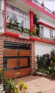 una casa con una puerta de madera en un garaje con plantas en Country Bug Inn, en Tagaytay