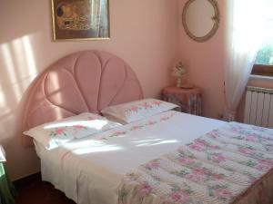ein rosa Bett mit einem rosa Kopfteil im Schlafzimmer in der Unterkunft Tavernamici in Anguillara Sabazia