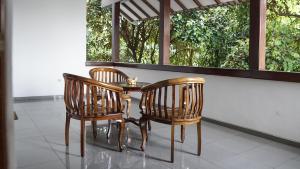 een tafel en twee stoelen en een tafel en een raam bij Ayodya Inn , Yogyakarta Lodging , Digital Nomads , Entrepreneurs Centre , CoWorking Space , CoLiving , Kost Lengkap , Exclusive Boarding House and Student Accommodation in Jogjakarta City Center ! in Yogyakarta