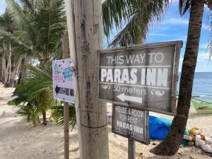 een bord dat zegt deze manier om panda's herberg op het strand bij Paras Inn Boracay in Boracay