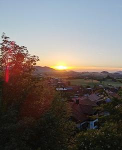 a sunset over a small town with houses and trees at Sunrise Belvedere Pfronten in Pfronten