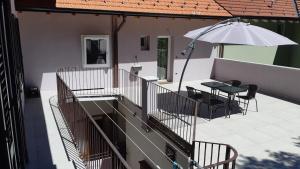 - Balcón con mesa y sombrilla en Guest House Green Heart, en Omegna